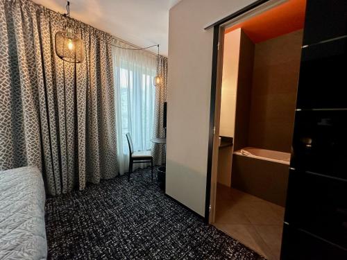 a hotel room with a bed and a window at The Originals Boutique, Hôtel de la Paix, Brest in Brest