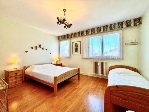 une chambre avec deux lits et deux fenêtres dans l'établissement Annecy centre - F2 spacieux avec balcon, parking privé, à 50m du lac - 2/3 pers - FR-1-432-23, à Annecy