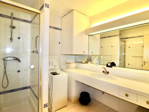 une salle de bain blanche avec un lavabo et une douche dans l'établissement Annecy centre - F2 spacieux avec balcon, parking privé, à 50m du lac - 2/3 pers - FR-1-432-23, à Annecy