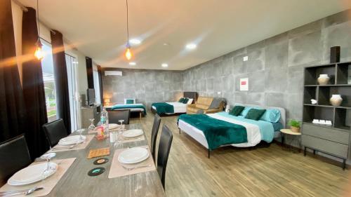 a room with a bed and a table with a dining room at Studio Geek Villa - Open Space - 5m from 5 top attractions - Pool all year round, Dining Pergola, Barbecue - Funchal Matrix Holiday Home in Funchal