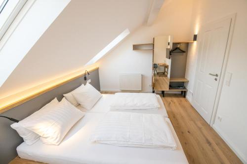 a bedroom with two white beds in a attic at NEU - Historisches Ferienhaus nahe Mosel & Eifel - Zentrum Wittlich - 4 Personen in Wittlich