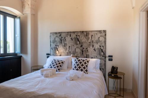 a bedroom with a large white bed with two pillows at Masseria Santo Scalone in Ostuni