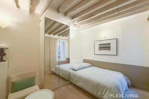 une petite chambre avec un lit et une chaise dans l'établissement Flexliving - Studio - Duvivier, à Paris