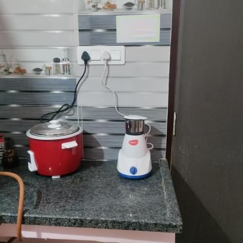 a kitchen counter with a blender and a pot at Jamuna homestays in Secunderabad