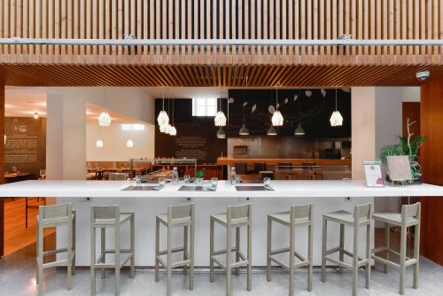 a large white bar with stools in a restaurant at Inspira Liberdade Boutique Hotel in Lisbon