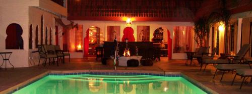 a pool in the middle of a room with tables and chairs at El Morocco Inn & Spa in Desert Hot Springs