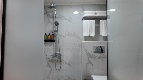 a bathroom with a shower with white towels at CC LUX Suites in Piraeus