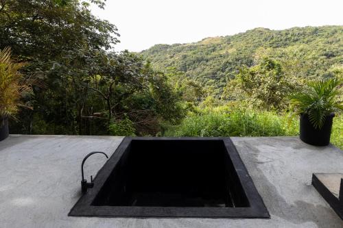 a concrete sink on top of a table with a mountain at Luxury 2 BR Cabin with Jacuzzi Valle de Antón in Puerto Frío