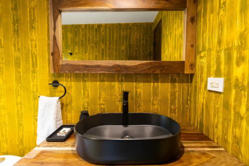 a bathroom with a black sink and a mirror at Luxury 2 BR Cabin with Jacuzzi Valle de Antón in Puerto Frío