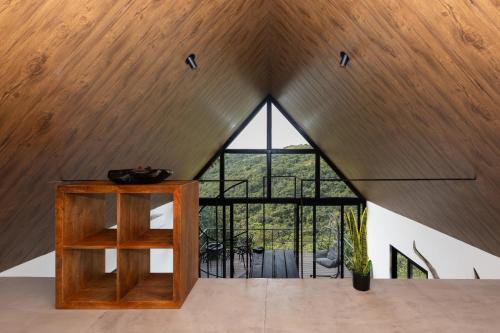 a room with a wooden ceiling and a large window at Luxury 2 BR Cabin with Jacuzzi Valle de Antón in Puerto Frío
