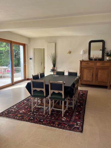 une salle à manger avec une table et des chaises sur un tapis dans l'établissement Maison de vacances avec piscine à 5 minutes de Périgueux, à Trélissac