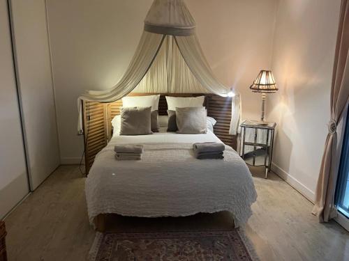 une chambre avec un grand lit à baldaquin dans l'établissement Maison de vacances avec piscine à 5 minutes de Périgueux, à Trélissac