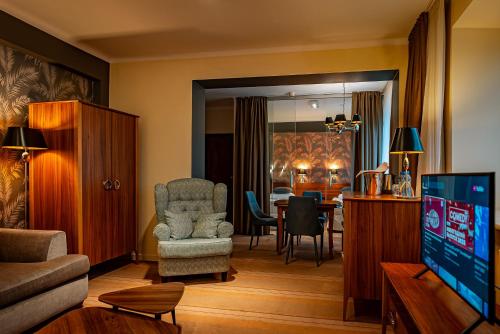 a living room with a television and a dining room at Hotel Cristal Białystok in Białystok