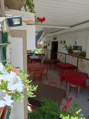 an empty restaurant with red tables and chairs at Albergo BELVEDERE in Santa Cristina Gela