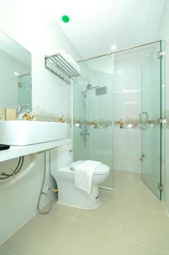 a bathroom with a toilet and a glass shower at HaTa Hotel in Quy Nhon