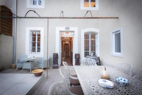 une salle à manger avec une table et des chaises blanches dans l'établissement Maison du canal du midi, à Carcassonne