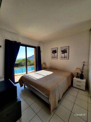 une chambre avec un lit et une grande fenêtre dans l'établissement Villa Pétale de Rose, à Cavalaire-sur-Mer