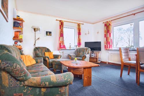 a living room with chairs and a table and a tv at Meerblick Hohenfelde in Monkamp