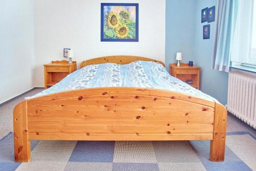a bedroom with a wooden bed with a wooden frame at Meerblick Hohenfelde in Monkamp