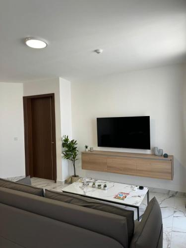 a living room with a flat screen tv on a wall at Spacious New 1 Bed with Balcony in Qawra