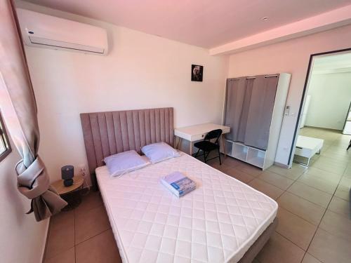 Appartement SOLEIL في كايان: غرفة نوم صغيرة بها سرير ومكتب