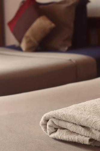 a white towel sitting on a bed with a pillow at Paradise Inn Beach Resort in Varkala