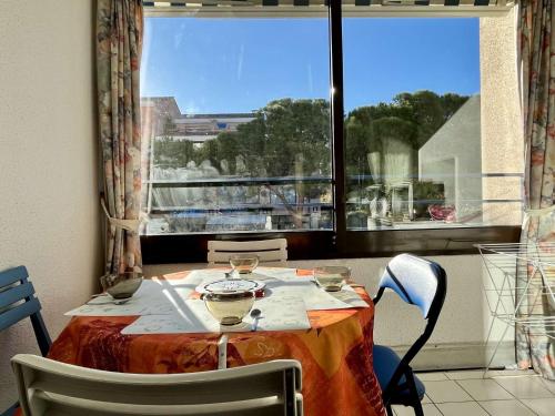 d'une table avec des chaises et d'une fenêtre avec vue. dans l'établissement Appartement 2 pièces cabine 4 couchages ARGELES SUR MER AR370-072, à Argelès-sur-Mer