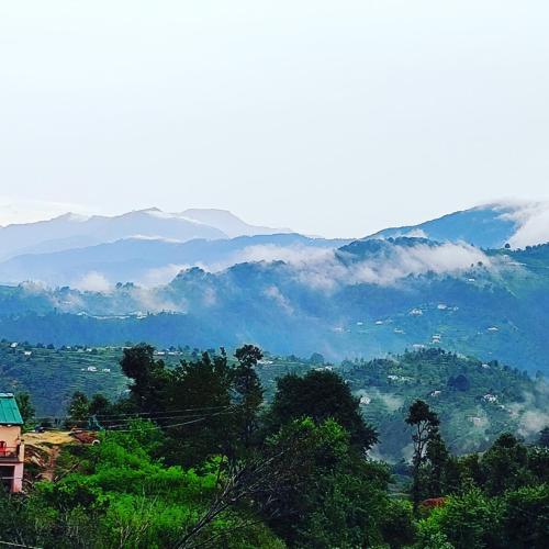 a view of a valley with mountains in the distance at Moonlight Camp Dhanachuli Mukteshwar in Nainital