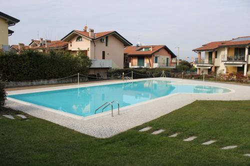 a swimming pool in a yard next to some houses at New Home Lazise in Lazise