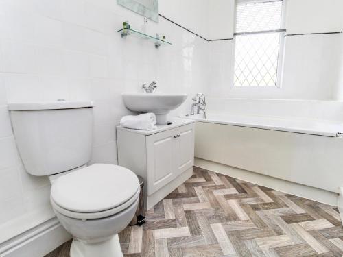 a white bathroom with a toilet and a sink at 2 Bed House, Sleeps 5, Ideal for Contractors, St Helens, Long Term Stays Weekly & Monthly Offers in Saint Helens