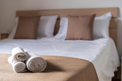 a bed with two rolled towels on top of it at Scandicci Elite Home - Casa Moderna con Cortile e Parcheggio Gratuito in Scandicci