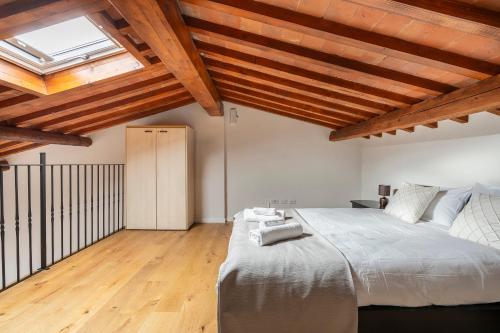 a bedroom with a large bed and wooden ceilings at Scandicci Elite Home - Casa Moderna con Cortile e Parcheggio Gratuito in Scandicci