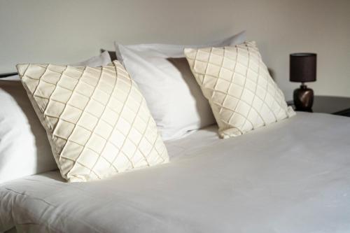 a bed with white pillows on top of it at Scandicci Elite Home - Casa Moderna con Cortile e Parcheggio Gratuito in Scandicci