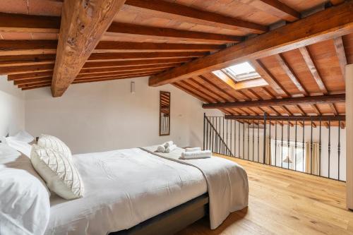 a bedroom with a large bed with wooden ceilings at Scandicci Elite Home - Casa Moderna con Cortile e Parcheggio Gratuito in Scandicci