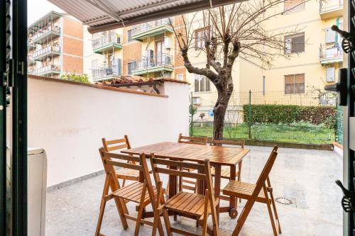 a wooden table and chairs on a patio at Scandicci Elite Home - Casa Moderna con Cortile e Parcheggio Gratuito in Scandicci