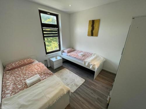 ein kleines Zimmer mit zwei Betten und einem Fenster in der Unterkunft Lebendige Stadtwohnung in Stadtnähe in Bremerhaven