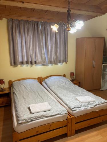 a bedroom with a bed with two towels on it at Lóbarát Panzió in Cserszegtomaj