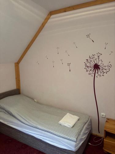 a bedroom with a dandelion sticker on the wall at Lóbarát Panzió in Cserszegtomaj