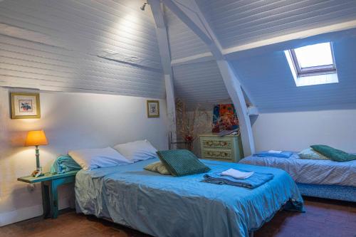 a bedroom with two beds and a blue ceiling at Chambre d'Hôtes Les Jardins de Marie, SCI Charles III in Bernay