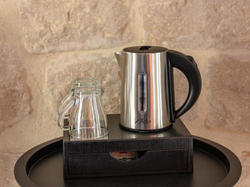 a tea kettle and a glass jar on a table at East Coast Deluxe Rooms in Split