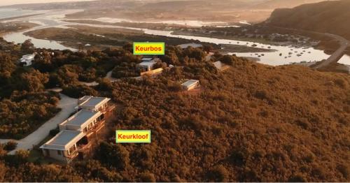 a group of buildings on a hill with trees at Alkantmooi Private Nature Reserve - Keurkloof & Keurbos 93 in Plettenberg Bay