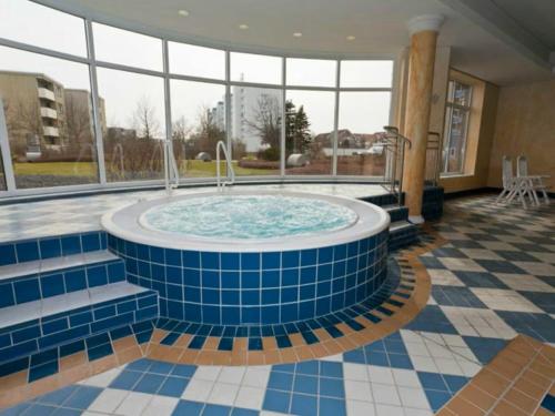 bañera de hidromasaje en el medio de una habitación con ventanas en Kurpark Residenz App 104, en Cuxhaven