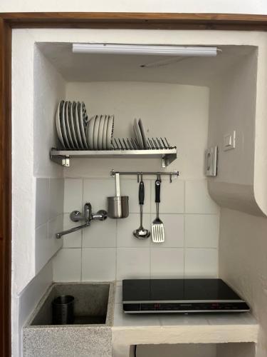 a kitchen with a sink and some plates and utensils at NUOVO Luminoso a 100 passi dalla piazza in Rio nellʼElba