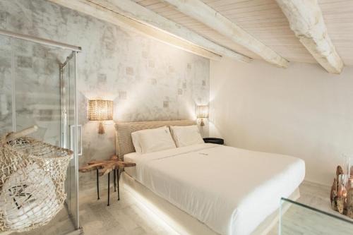 a white bedroom with a bed and a glass shower at Blue Carpet Luxury Suites in Pefkohori