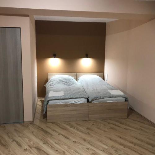a bedroom with a bed with white sheets on it at Lóbarát Panzió in Cserszegtomaj