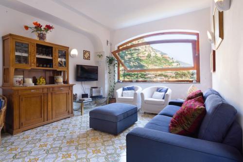 un soggiorno con un divano blu e una finestra di Villa D'apuzzo nel cuore di Positano a Positano