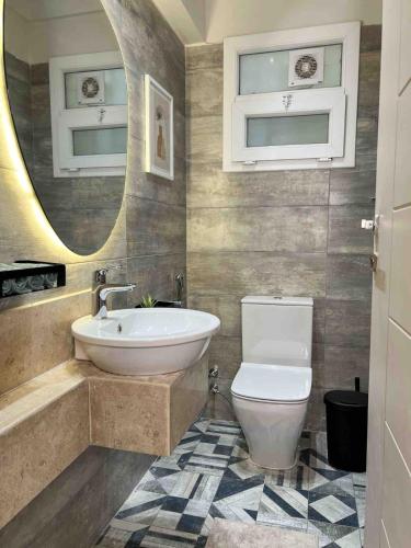 a bathroom with a sink and a toilet and a mirror at 6th Of October Signature Stay in 6th Of October