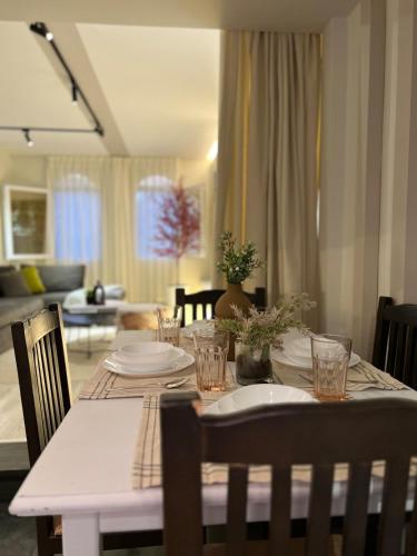 a dining room table with plates and glasses on it at 6th Of October Signature Stay in 6th Of October