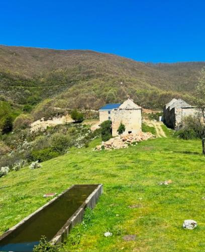 a field of green grass with a building on a hill at Hotel & Restaurante El Casino in Villafranca del Bierzo
