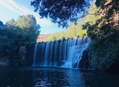 a waterfall in front of a pool of water at Hotel & Restaurante El Casino in Villafranca del Bierzo